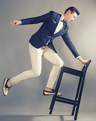 Image showing young handsoman businessman fooling aroung with chair, modern mem