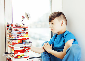 Image showing little cute preschooler boy playing lego toys at home happy smil