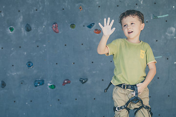 Image showing little boy climbing a rock wall