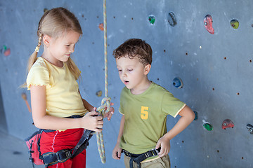 Image showing brother and sister standing near a rock wall for climbing