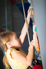 Image showing little girl climbing a rock wall