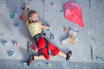 Image showing little girl climbing a rock wall