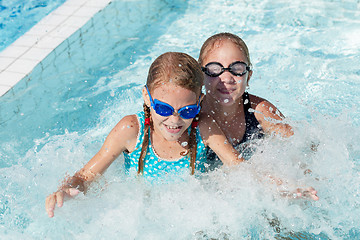 Image showing Two happy children playing on the swimming pool at the day time.