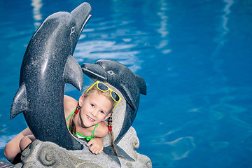 Image showing One  happy little girl playing near swimming pool at the day tim