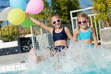 Image showing Two happy children playing on the swimming pool at the day time.