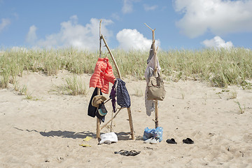 Image showing clothes hanging on the wooden poles at the beach