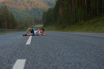 Image showing Man laying on the road