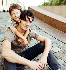 Image showing Young father hipster and his little son outside. Talking, teaching, hugging, having fun happy time. Lifestyle people concept 