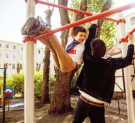 Image showing Young father hipster and his little son outside. Talking, teaching, hugging, having fun happy time. Lifestyle people concept 