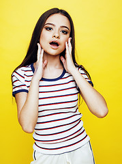 Image showing young pretty teenage woman angry posing on yellow background, fashion lifestyle people concept