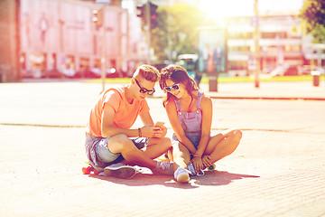 Image showing couple with skateboards and smartphone in city