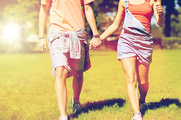 Image showing happy teenage couple walking at summer park