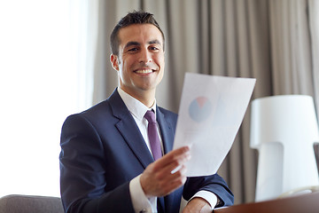 Image showing businessman with papers working at hotel room