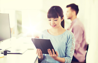 Image showing happy creative female office worker with tablet pc