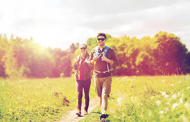 Image showing happy couple with backpacks hiking outdoors