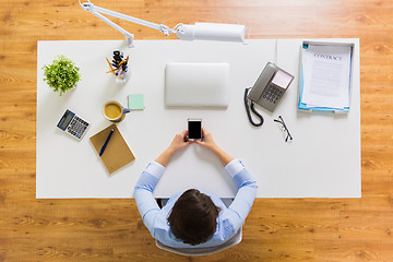 Image showing businesswoman with smartphone working at office