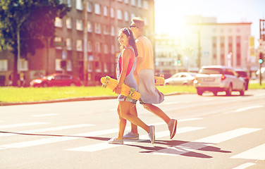 Image showing teenage couple with skateboards on city street