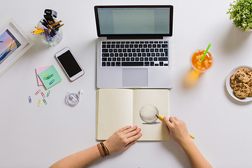 Image showing woman hands drawing in notebook at home office