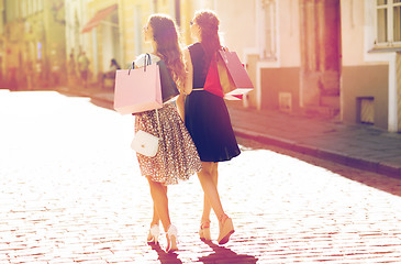 Image showing happy women with shopping bags walking in city 