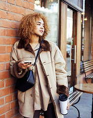 Image showing young pretty african american women drinking coffee outside in c