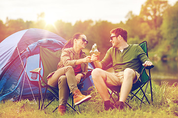 Image showing happy couple clinking drinks at campsite tent