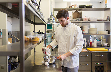 Image showing happy male chef cooking food at restaurant kitchen