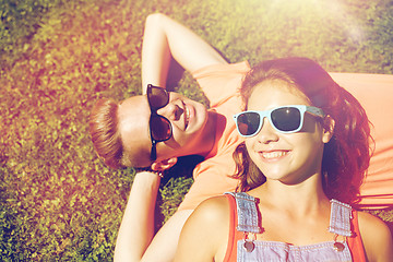 Image showing happy teenage couple lying on grass at summer