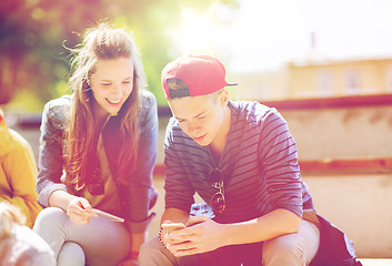 Image showing happy teenage friends with smartphones outdoors