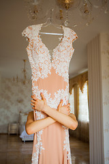 Image showing Bride hugging wedding dress