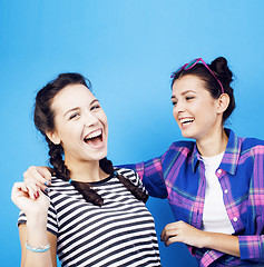 Image showing best friends teenage school girls together having fun, posing on blue background, besties happy smiling, lifestyle people concept