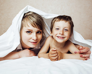 Image showing young blond woman with little boy in bed, mother and son, happy 