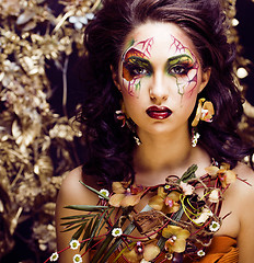 Image showing beauty woman with face art and jewelry from flowers orchids clos