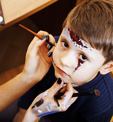 Image showing little cute child making facepaint on birthday party, zombie Apo