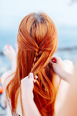 Image showing Woman braiding girl on beach