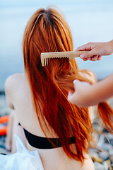 Image showing Anonymous person brushing girl\'s hair