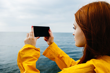 Image showing Girl taking photo of ocean