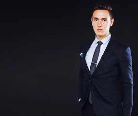 Image showing young pretty business man standing on black background, modern h