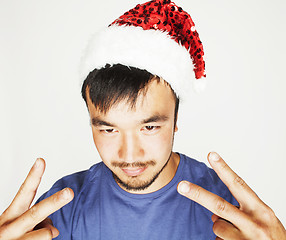 Image showing funy exotical asian Santa claus in new years red hat smiling