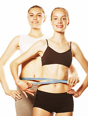 Image showing two sport girls measuring themselves isolated on white