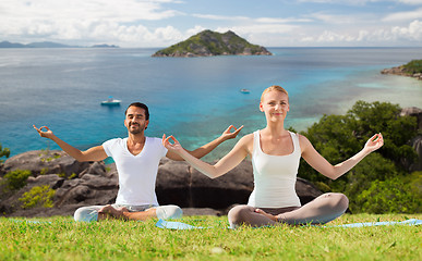 Image showing happy couple doing yoga and meditating outdoors