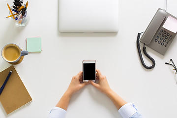 Image showing businesswoman with smartphone working at office