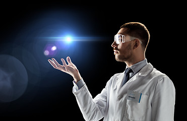 Image showing scientist in lab coat and goggles with laser light