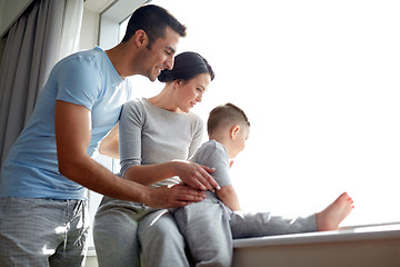 Image showing happy family looking through window at home