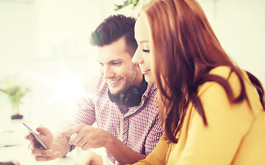 Image showing happy creative team with smartphones at office