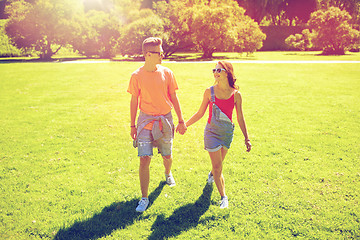 Image showing happy teenage couple walking at summer park