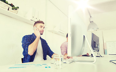 Image showing happy creative man calling on cellphone at office