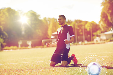 Image showing happy soccer player with ball on football field