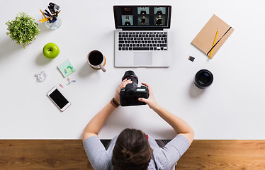 Image showing woman with camera and laptop at office table