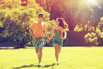 Image showing happy teenage couple running at summer park