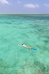 Image showing Woman snorkeling in clear shallow sea of tropical lagoon with turquoise blue water.